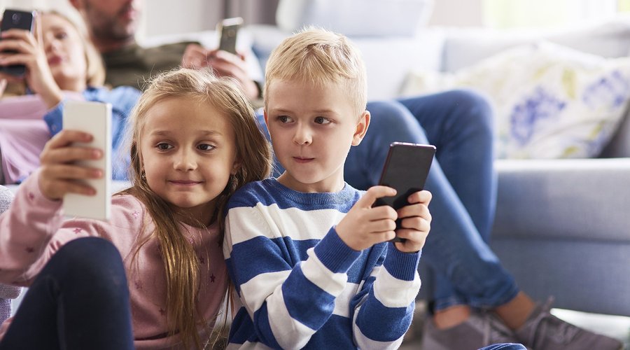 children-using-mobile-phone-living-room